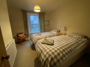 1 dormitorio con 2 camas y ventana en lake District cottage, en Bootle