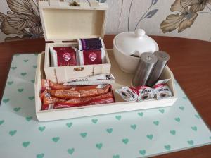 a box of chocolates and other items on a table at Begónia-dom s jednou spálňou in Bešeňová