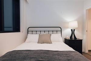um quarto com uma cama e um candeeiro numa mesa de cabeceira em Chic Urban Oasis em Melbourne