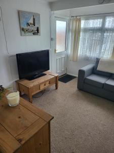 uma sala de estar com um sofá e uma televisão em #31 Sundowner em Great Yarmouth