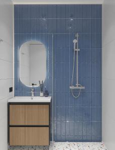 een blauw betegelde badkamer met een wastafel en een spiegel bij Blueloft 47 l studio with balcony in Tasjkent