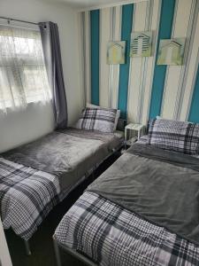 1 dormitorio con 2 camas, ventana y paredes azules en #31 Sundowner en Great Yarmouth