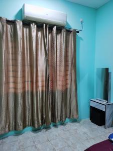 a curtain in a room with a television at Homestay Che Naa in Kuantan