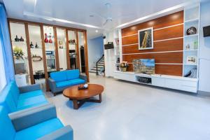 a living room with blue chairs and a table at Villa Pearl FLCSầm Sơn in Sầm Sơn