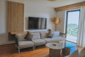 uma sala de estar com um sofá e uma televisão de ecrã plano em Truntum Boutique Mandalika em Kuta Lombok