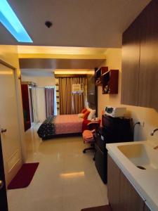 um quarto com uma cama e uma cozinha com um lavatório em Studio at La Guardia em Cebu