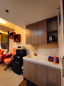 a kitchen with a sink and a room with a bed at Studio at La Guardia in Cebu City