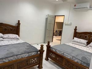 a bedroom with two beds and a mirror at AlFarizqi Muslim Residence SP in Sungai Petani