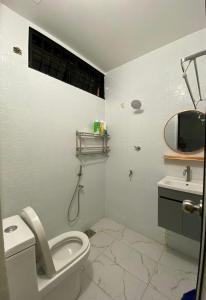 a white bathroom with a toilet and a sink at AlFarizqi Muslim Residence SP in Sungai Petani