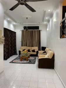 a living room with two couches and a ceiling fan at AlFarizqi Muslim Residence SP in Sungai Petani