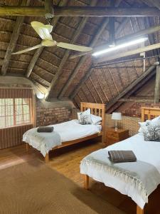 a attic bedroom with two beds and a ceiling at Intundla's Rest in Marloth Park