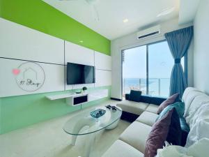 ein Wohnzimmer mit einem Sofa und einem Glastisch in der Unterkunft SilverScape 4px Seaview Bathtub TVBox Games in Malakka