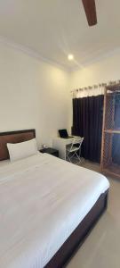 um quarto com uma cama e uma secretária com um computador portátil em Happy Seas Beach Villa em Alappuzha