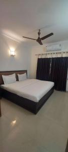 um quarto com uma cama grande e uma ventoinha de tecto em Happy Seas Beach Villa em Alappuzha