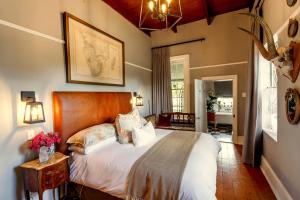 a bedroom with a large bed with a wooden headboard at Oude Pastorie in Nieu-Bethesda