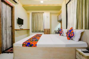 um quarto com uma cama grande e uma televisão em FabHotel Happy Homely Stay em Pune