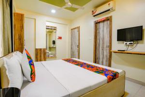 a bedroom with a bed and a flat screen tv at FabHotel Happy Homely Stay - Airport road in Pune
