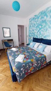 a bedroom with a large bed with a blue headboard at Casa di Raffi Sanremo in Sanremo