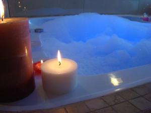 a lit candle is lit in a bathtub at Hotel Necof in Rosario