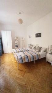 a bedroom with a large bed and a wooden floor at Casa di Raffi Sanremo in Sanremo