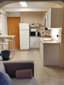 a kitchen with a white refrigerator and a table at Apartament Ampolla Port in L'Ampolla