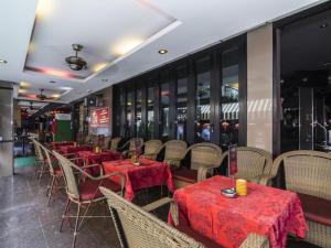 芭達雅中心的住宿－Copa Hotel，餐厅配有桌椅和红色桌布