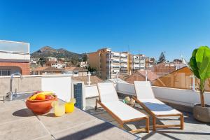 un balcone con 2 sedie e un cesto di frutta di Solaga - Jabega a Málaga