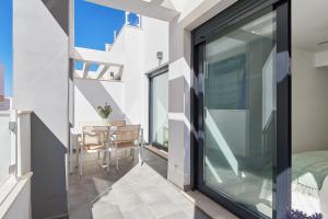 a room with a balcony with a table and a glass door at Solaga - Jabega in Málaga