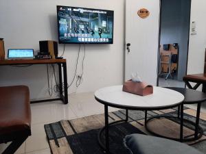 a room with a table and a television on a wall at 秧月民宿 in Hsia-san-chieh