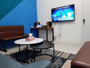 a living room with a table and a tv on a wall at 秧月民宿 in Hsia-san-chieh