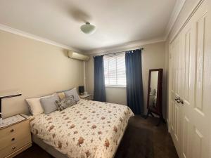 a bedroom with a bed and a window and a mirror at Joondalup Guest House in Perth