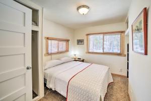 - une chambre avec un lit et 2 fenêtres dans l'établissement Peaceful Marquette Cottage with Sunroom!, à Marquette