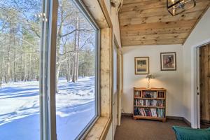 a room with a window looking out at a snow covered yard at Peaceful Marquette Cottage with Sunroom! in Marquette