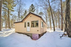 a tiny house in the woods in the snow at Peaceful Marquette Cottage with Sunroom! in Marquette