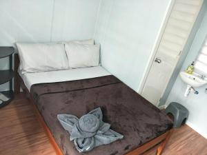 ein kleines Bett in einem kleinen Zimmer mit Waschbecken in der Unterkunft Olive Hostel Roxas City in Roxas City