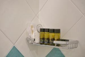 a shelf on a wall with four bottles of oil at Casa Adelaide in Capri
