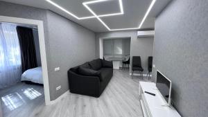 uma sala de estar com um sofá e um quarto em Modern Gagarina Avenue em Dnipro