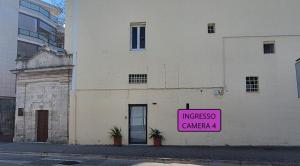 ein rosa Schild an der Seite eines Gebäudes in der Unterkunft Villino Tortorelli con Self Check-in in Matera