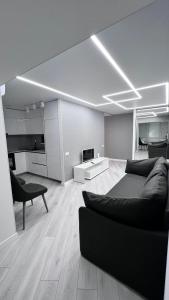 聶伯城的住宿－Modern Gagarina Avenue，一间带黑色沙发的客厅和一间带