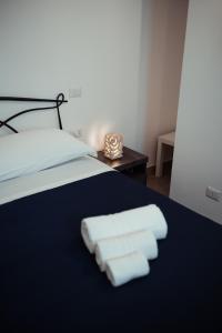 ein Bett mit drei gefalteten Handtüchern darauf in der Unterkunft Villino Tortorelli con Self Check-in in Matera
