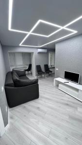 ein Wohnzimmer mit Sofa und TV in der Unterkunft Modern Gagarina Avenue in Dnipro