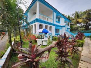a blue and white house with plants in front of it at Paradise Village Beach Resort in Calangute