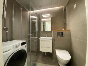 a bathroom with a washing machine and a toilet at City Apartment Sotilaskatu in Iisalmi +13 photos