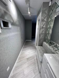 ein Bad mit einem Sofa und einem Waschbecken in einem Zimmer in der Unterkunft Modern Gagarina Avenue in Dnipro