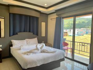 ein Schlafzimmer mit einem Bett und einem großen Fenster in der Unterkunft Hill View Lodge in Patong Beach