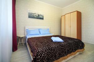 a bedroom with a bed with blue pillows on it at ЖК Радужный берег РБ 14 in Turksib