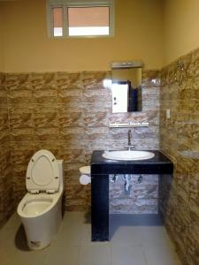 a bathroom with a toilet and a sink at HOTEL CROWN HORIZON in Sauraha