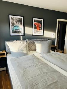 zum Herzog : سرير كبير في غرفة نوم مع ثلاث صور على الحائط