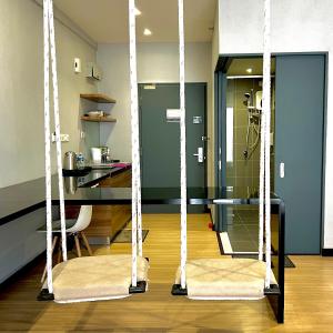 two swings in a living room with a kitchen at Aeropod Studio - Laxzone in Kota Kinabalu