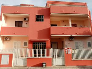 a red building with white fences in front of it at A Casa di Maria 2 in Cavallino di Lecce
